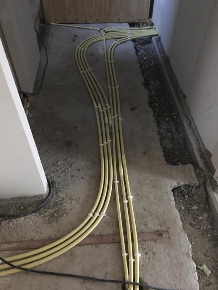 Een strakke bundel leidingen langs de wand van een nieuwbouwwoning